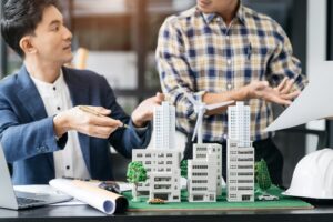 Business professionals discussing building models and a development proposal